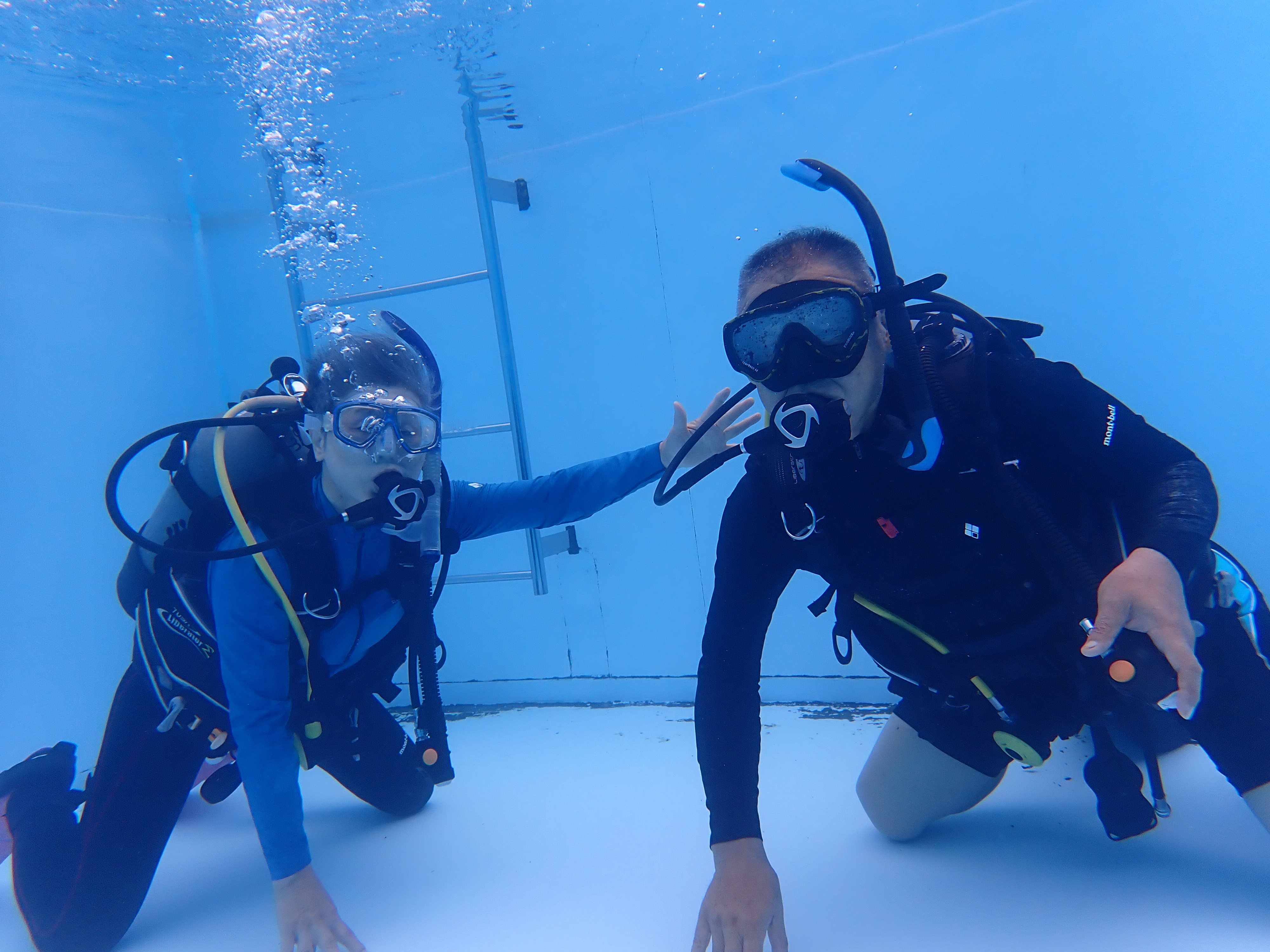 専用プールでインストラクターと一緒にダイビング練習をする様子